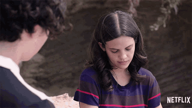 a girl in a striped shirt is sitting next to a boy in a netflix advertisement