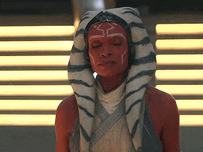 a woman with red paint on her face is wearing a turban and headphones .