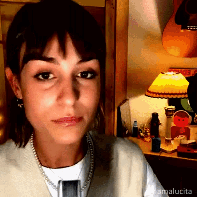 a woman is sitting in front of a lamp with the name mamalucia written on the bottom