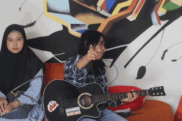 a woman playing a guitar with a sticker on it that says ' i am not a fan '