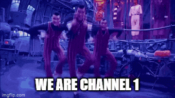 a group of men in red overalls are dancing in a room with the words `` we are channel 1 '' written below them .