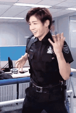 a man in a police uniform is standing in an office