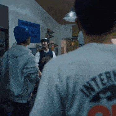 a man wearing a white shirt that says " intern " on the back