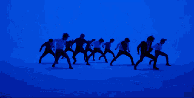 a group of young men are dancing in a room