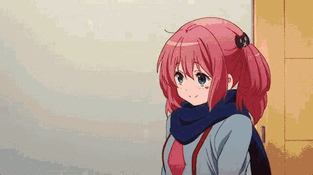 a girl with pink hair and a scarf around her neck is standing in front of a wall .