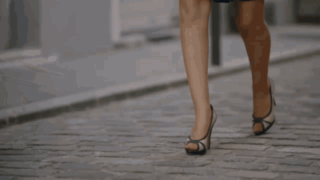 a woman in a blue dress is walking past a car