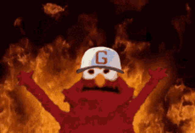 elmo from sesame street wearing a white hat with the letter g on it