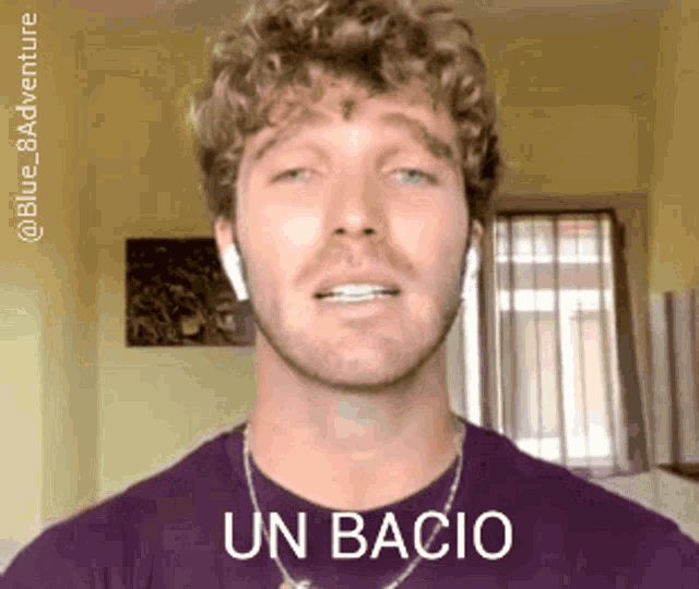 a man wearing a purple shirt says " un bacio "