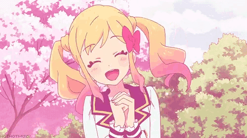 a girl with blonde hair and pink pigtails is smiling in front of pink trees