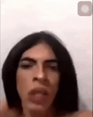 a woman with long black hair is making a funny face while talking on a phone .