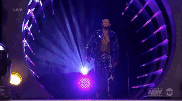 a man is walking through a tunnel with a aew logo on the bottom right