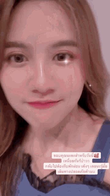a close up of a woman 's face with a foreign language sticker on it