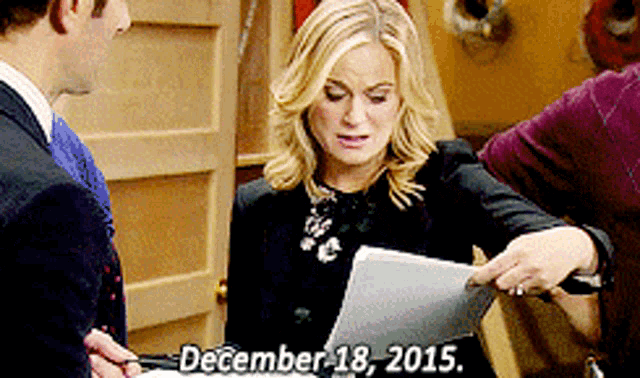 a woman is holding a piece of paper with the date december 18 2015 on it