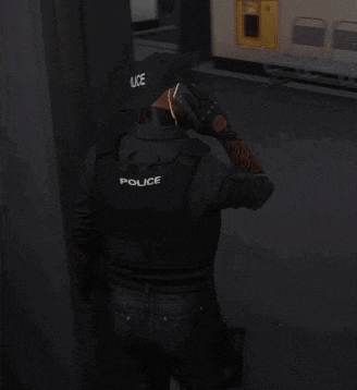 a man in a police uniform is talking on a cell phone in a waiting room .