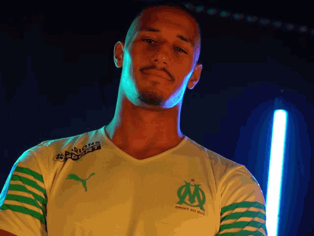 a man wearing a white shirt with green stripes and a puma logo