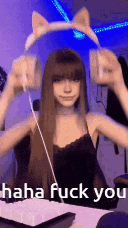 a girl wearing a cat ear headband is holding a remote control and says `` haha fuck you '' .