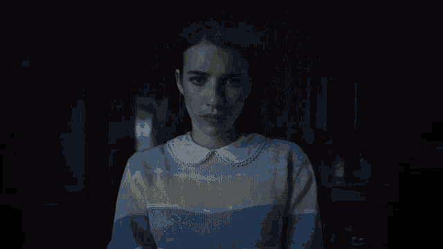 a woman is holding a flashlight in her hand in the dark