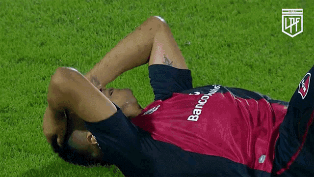 a soccer player is laying on the grass with his hands on his head