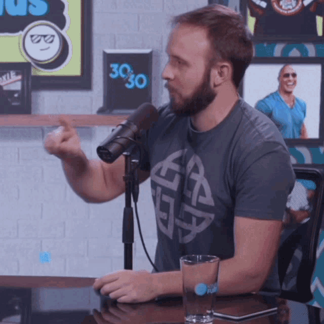 a man sitting in front of a microphone with a sign that says 3030 on it