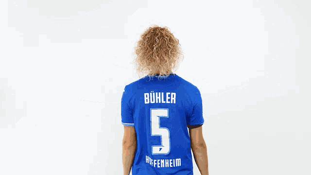a woman in a blue shirt with the number 5 on the back