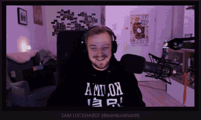 a man wearing a black shirt that says amnon is smiling