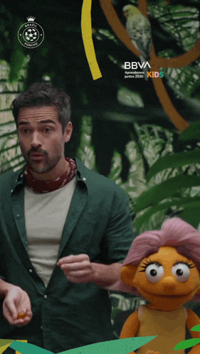 a man standing next to a stuffed animal with a bbva kids logo on the bottom right