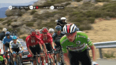 a group of cyclists are riding down a road and one of them is wearing a skoda jersey