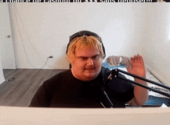 a man is sitting in front of a microphone and waving