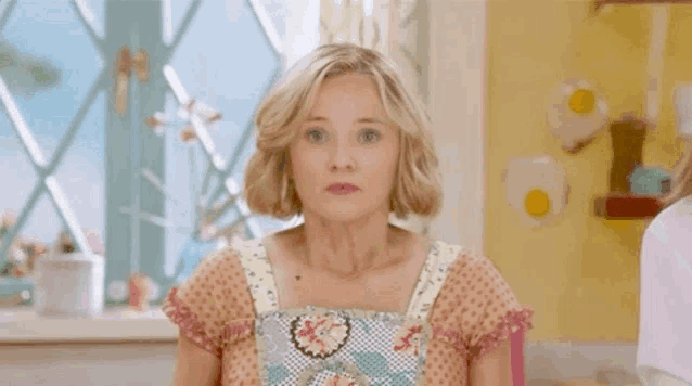 a woman in a floral dress is making a funny face .