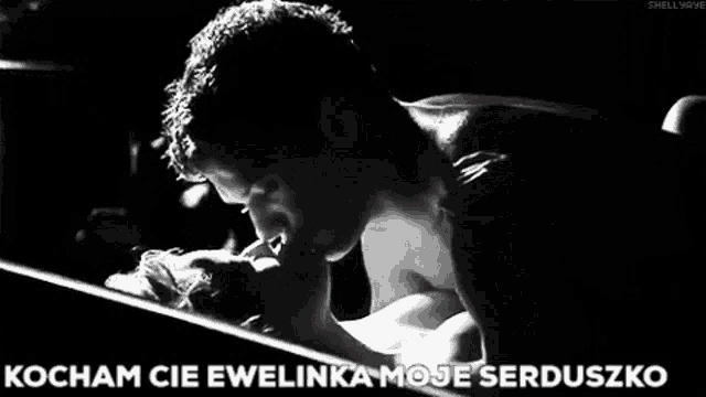 a black and white photo of a man kissing a woman with the caption kocham cie ewelinka moje serduszko