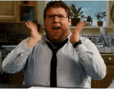 a man wearing glasses and a tie is making a funny face in a kitchen