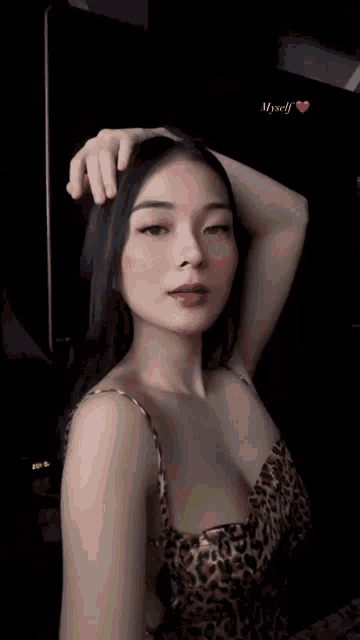 a woman in a leopard print top holds her hand to her head and says myself