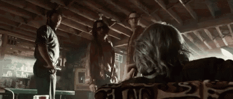 a group of people are standing around a table in a bar .