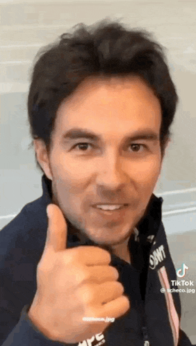 a man is giving a thumbs up and smiling at the camera .