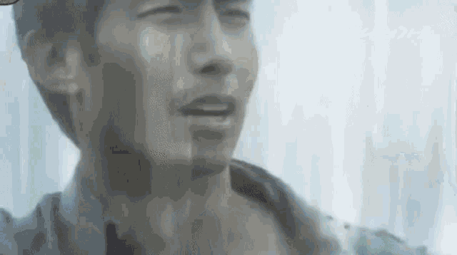 a close up of a man 's face with his eyes closed and a beard .