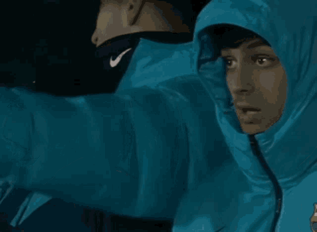 a man wearing a blue jacket with a fcb logo on the front