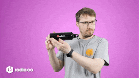 a man holding a water bottle with the word radio.co on it
