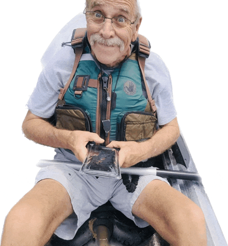 an older man wearing a life vest and glasses is sitting in a boat