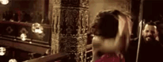 a woman is standing in front of a mirror in a dark room .