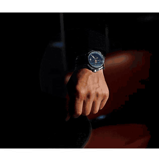 a man wearing a watch with a red face that says tictac