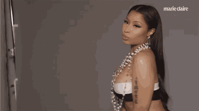 a woman is wearing a pearl necklace and a black and white bra