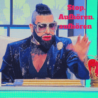 a man with a beard wearing sunglasses and a blue suit says " stop "