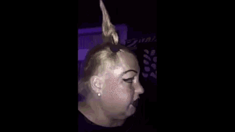 a woman with a unicorn horn on her head is talking to someone .