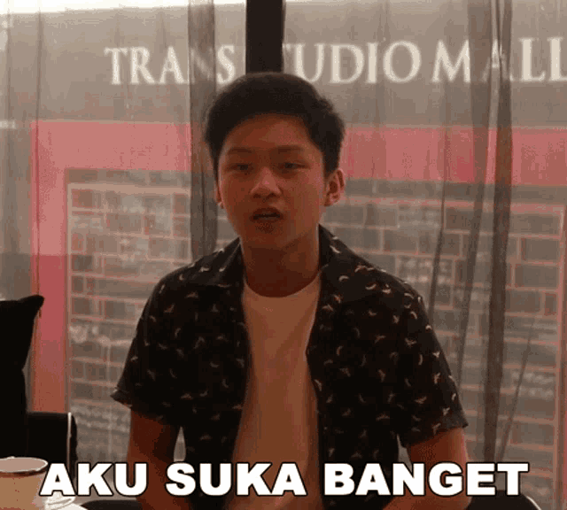 a young man says aku suka banget in front of a trans studio mall building