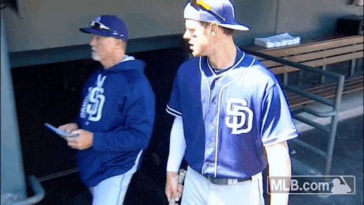 a man in a san diego padres jersey walks with another man