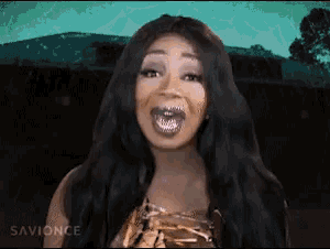 a woman with long black hair is making a funny face and the words savionce are on the bottom right