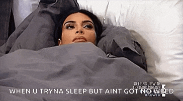 a woman is laying in a bed under a blanket with a caption .