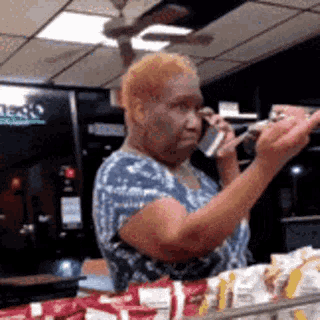 an elderly woman is talking on a cell phone in a store