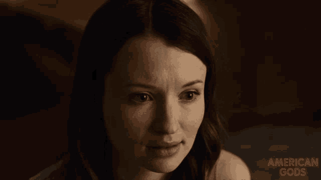 a close up of a woman 's face with the words american gods on the bottom right