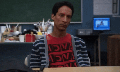 a man wearing a red shirt that says " adva " sits at a desk